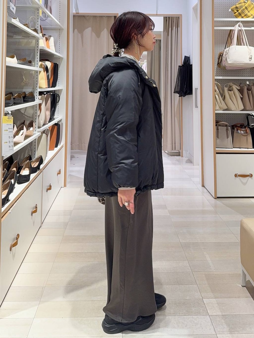 その他のショルダーバッグ、ブラック系のダウンジャケット/コート、ホワイト系のニット/セーターを着用したレディースの冬コーディネートの3枚目の写真