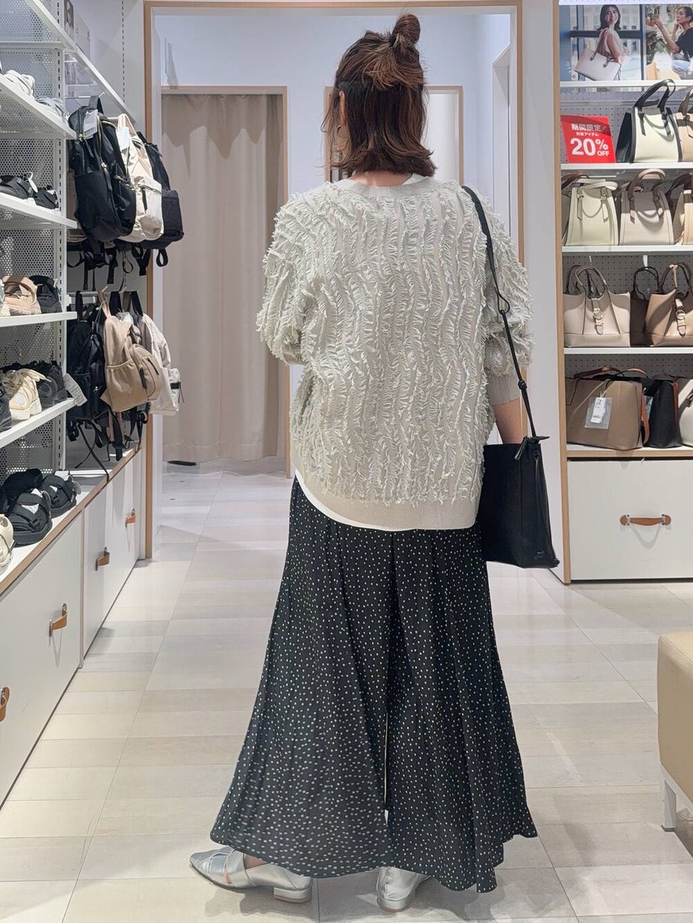 ブルー系のデニムパンツ、ブラック系のショルダーバッグ、ブラック系のタンクトップを着用したレディースの春コーディネートの6枚目の写真