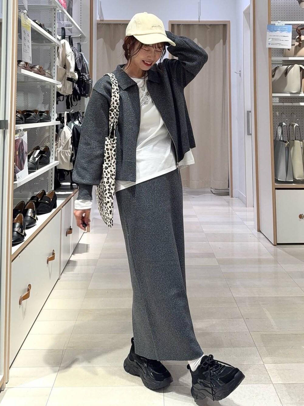 ブラック系のスニーカー、ブルー系のデニムジャケット、シルバー系のハンドバッグを着用したレディースの秋コーディネートの3枚目の写真