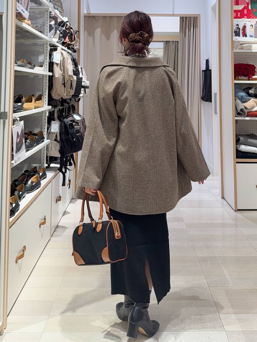 ブラウン系のチェスターコート、ホワイト系のTシャツ/カットソー、ブラウン系のニット/セーターを着用したレディースの冬コーディネートの6枚目の写真