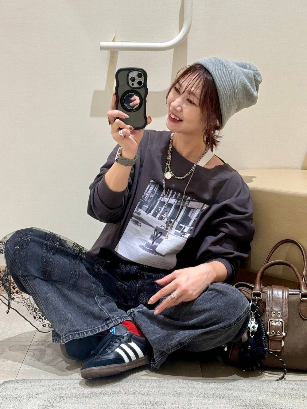 グレー系のスウェット、ブラック系のデニムパンツ、ブラック系のその他トップスを着用したレディースの秋コーディネートの2枚目の写真