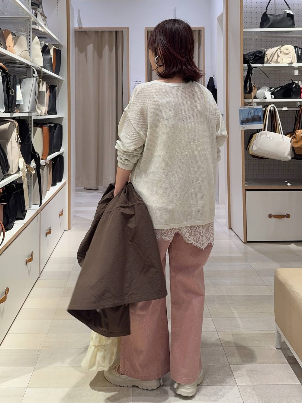 ベージュ系のトートバッグ、ブラウン系のパーカー、ピンク系のデニムパンツを着用したレディースの春コーディネートの7枚目の写真