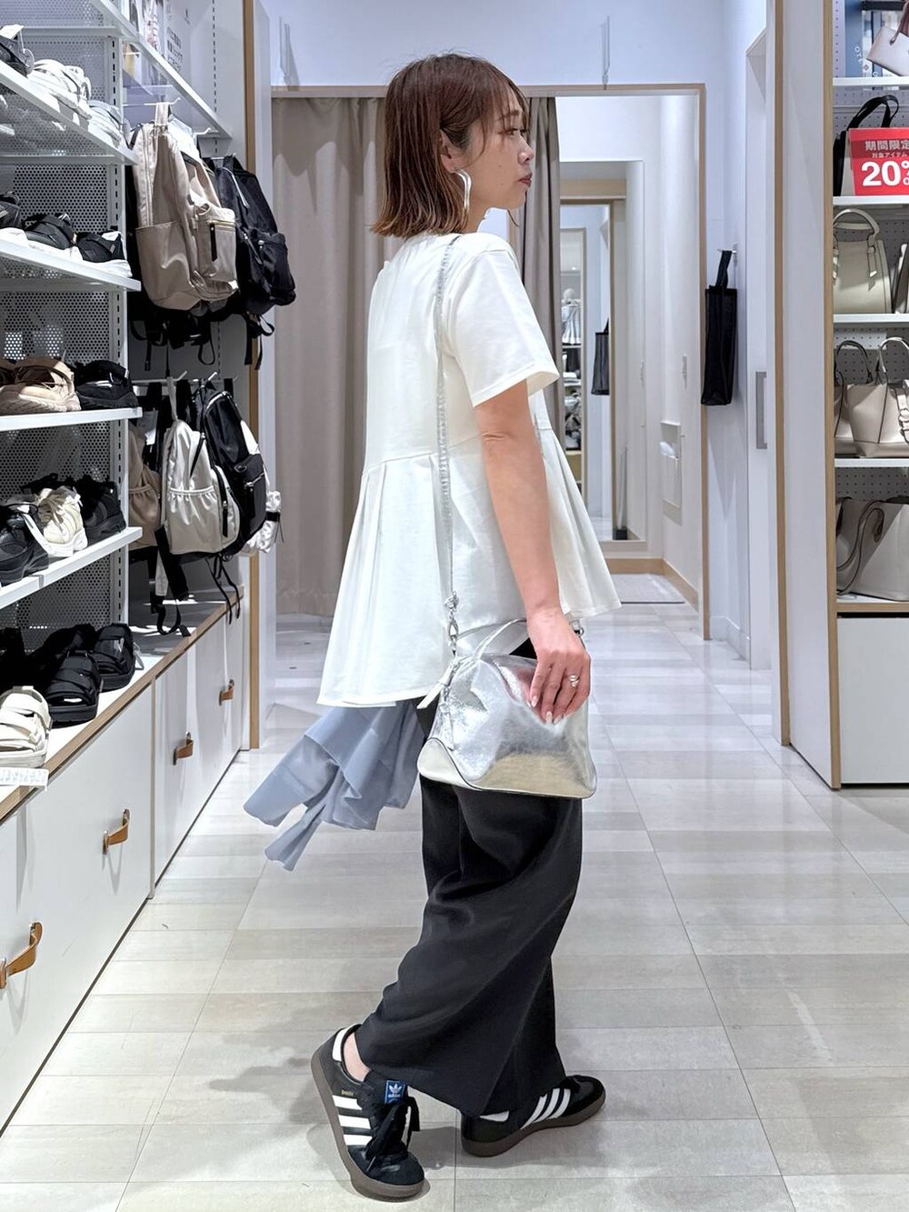 シルバー系のショルダーバッグ、ブルー系のカーディガン/ボレロ、ホワイト系のTシャツ/カットソーを着用したレディースの春コーディネートの6枚目の写真