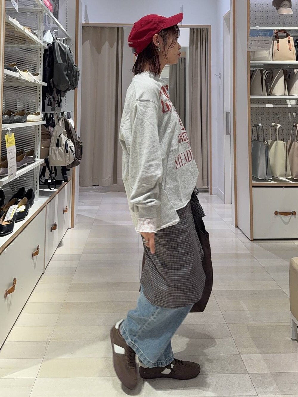 ブルー系のデニムパンツ、ブラウン系のトートバッグ、ブラウン系のシャツ/ブラウスを着用したレディースの秋コーディネートの6枚目の写真