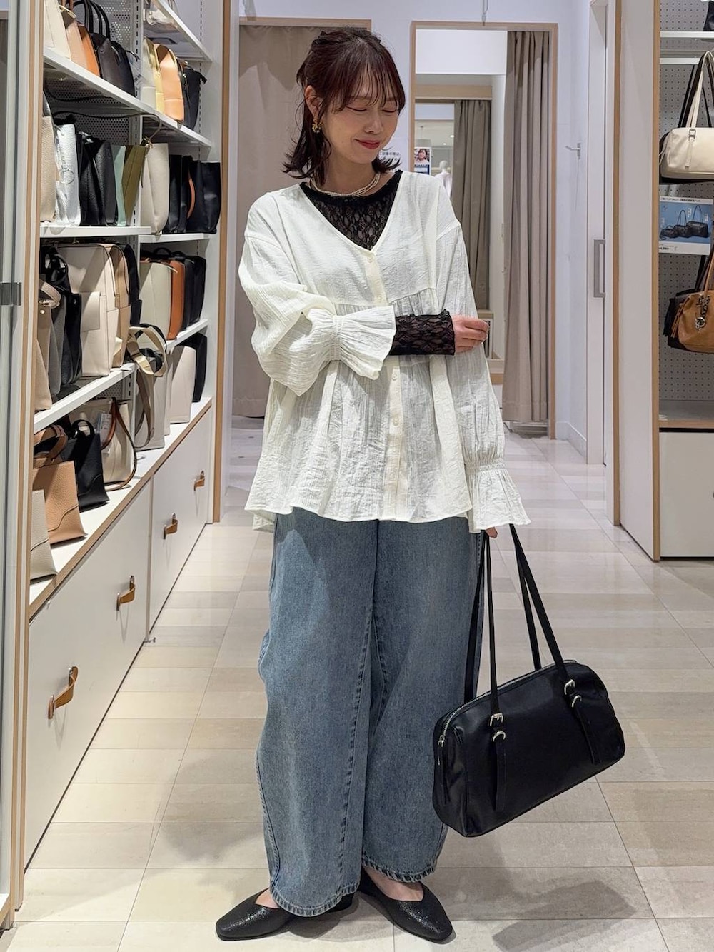 ホワイト系のスカート、ブラック系のパンプス、ゴールド系のネックレスを着用したレディースの春コーディネートの7枚目の写真