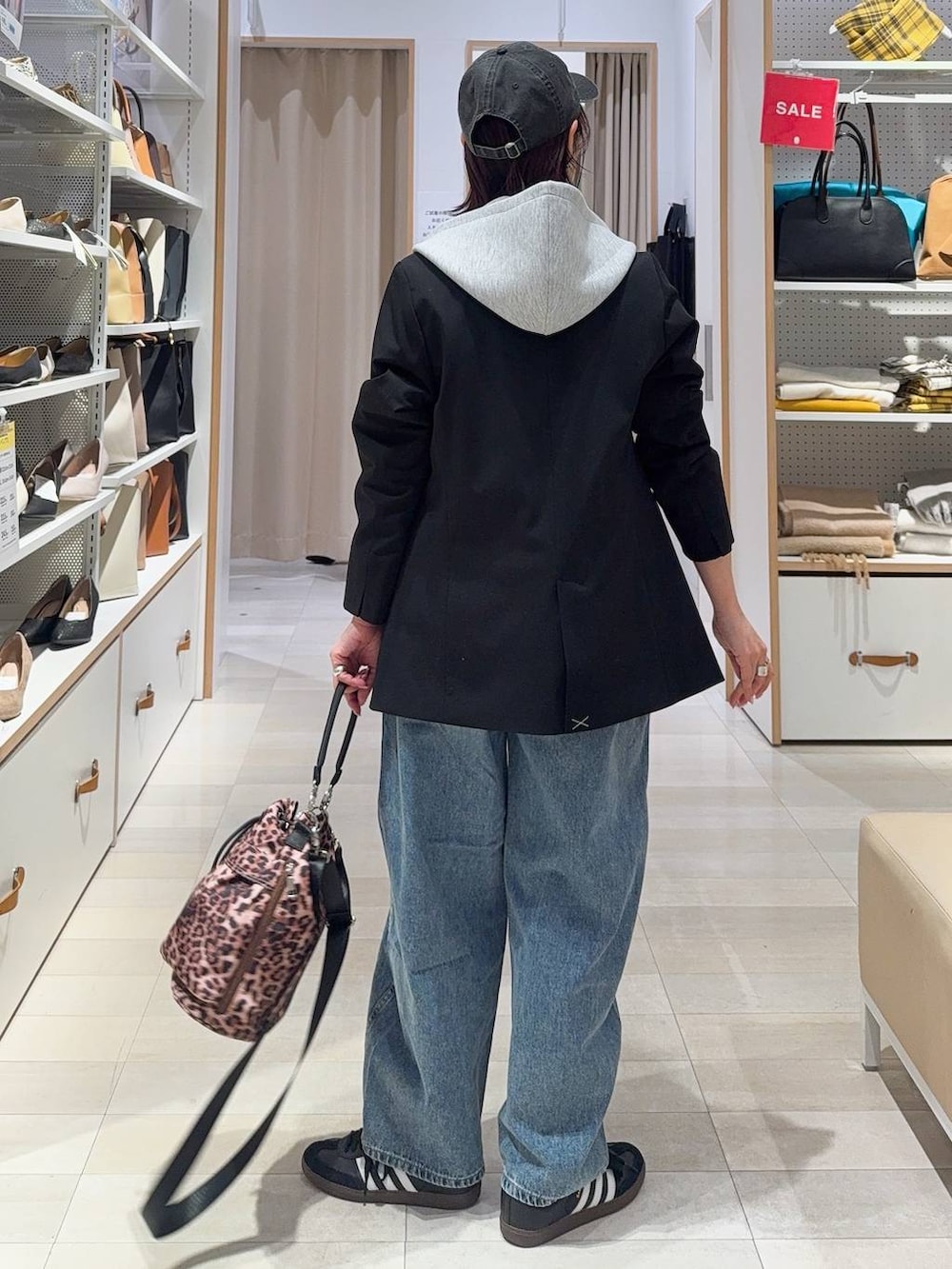 ブラック系のキャミソール、ブラック系のテーラードジャケット、ブルー系のデニムパンツを着用したレディースの冬コーディネートの6枚目の写真