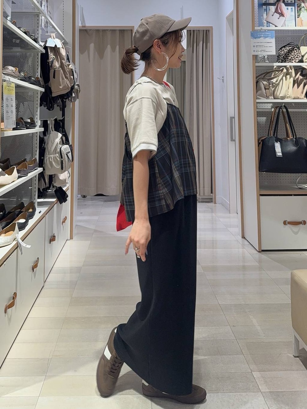 レッド系のトートバッグ、ブラック系のキャミソール、ブラック系のスカートを着用したレディースの夏コーディネートの2枚目の写真