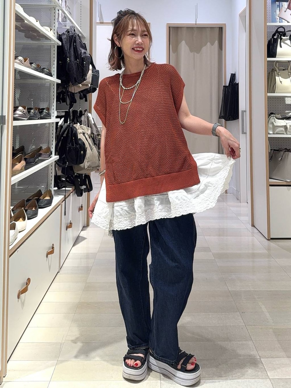 ブルー系のデニムパンツ、ベージュ系のキャミソール、ブラウン系のTシャツ/カットソーを着用したレディースの夏コーディネートの3枚目の写真