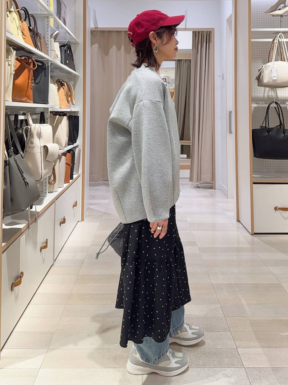 ホワイト系のスニーカー、ブルー系のデニムパンツ、ホワイト系のニット/セーターを着用したレディースの冬コーディネートの4枚目の写真