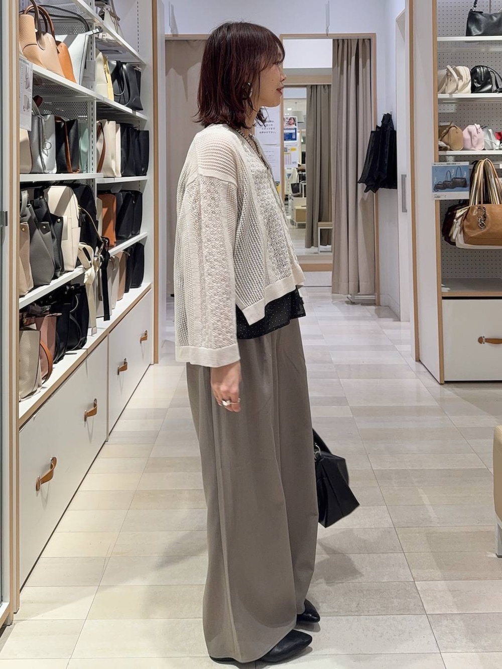 ブラック系のパンプス、ブラウン系のその他パンツ、シルバー系のネックレスを着用したレディースの春コーディネートの2枚目の写真