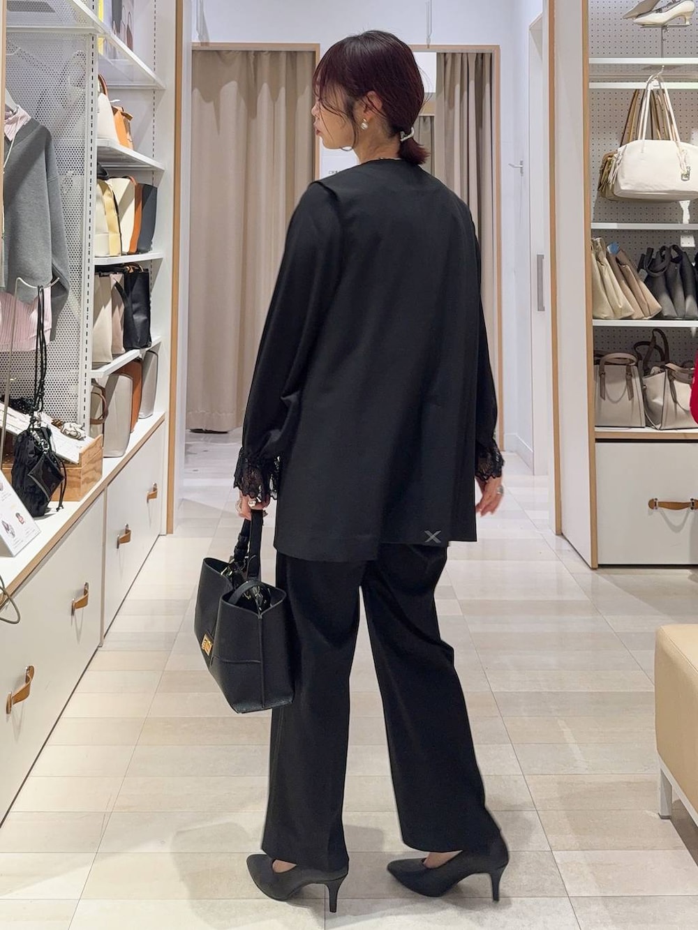 ブラック系のシャツ/ブラウス、ブラック系のスラックス、ブラック系のその他アウターを着用したレディースの冬コーディネートの6枚目の写真