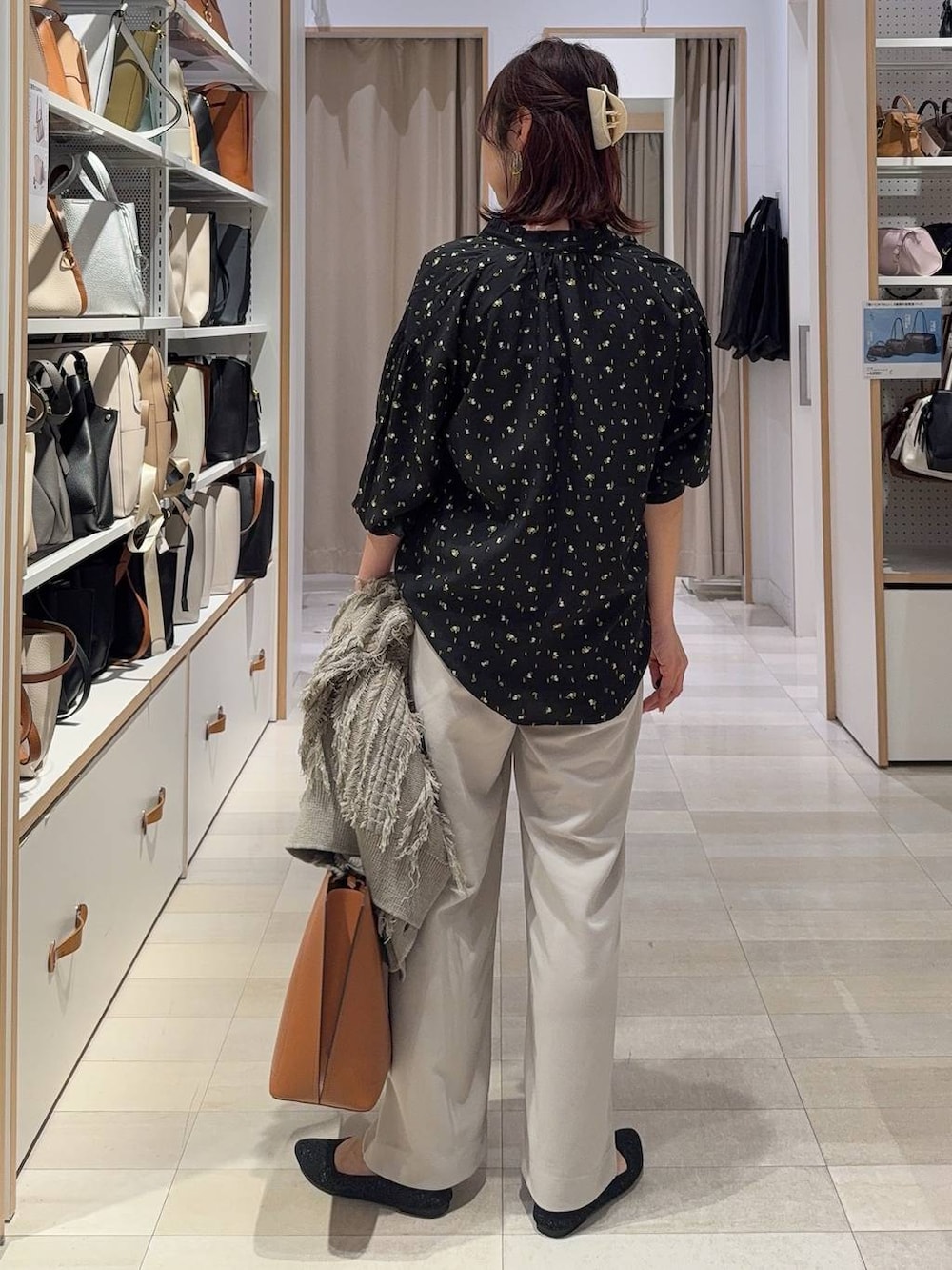 ブラック系のシャツ/ブラウス、ブラウン系のトートバッグ、ブラック系のパンプスを着用したレディースの春コーディネートの7枚目の写真