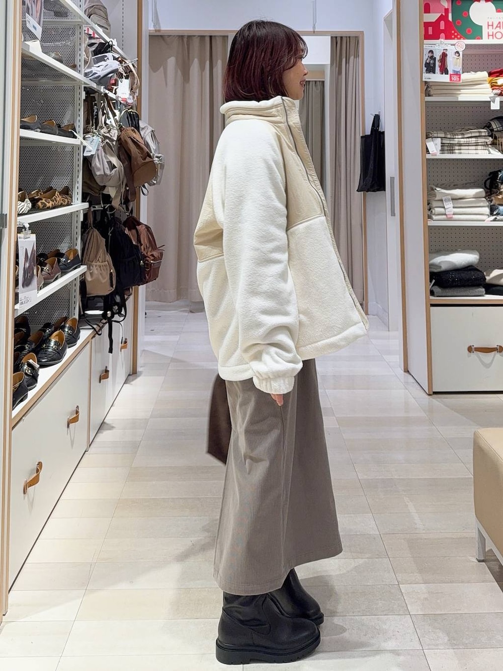 ブラウン系のスカート、ブラウン系のトートバッグ、ホワイト系のTシャツ/カットソーを着用したレディースの冬コーディネートの4枚目の写真