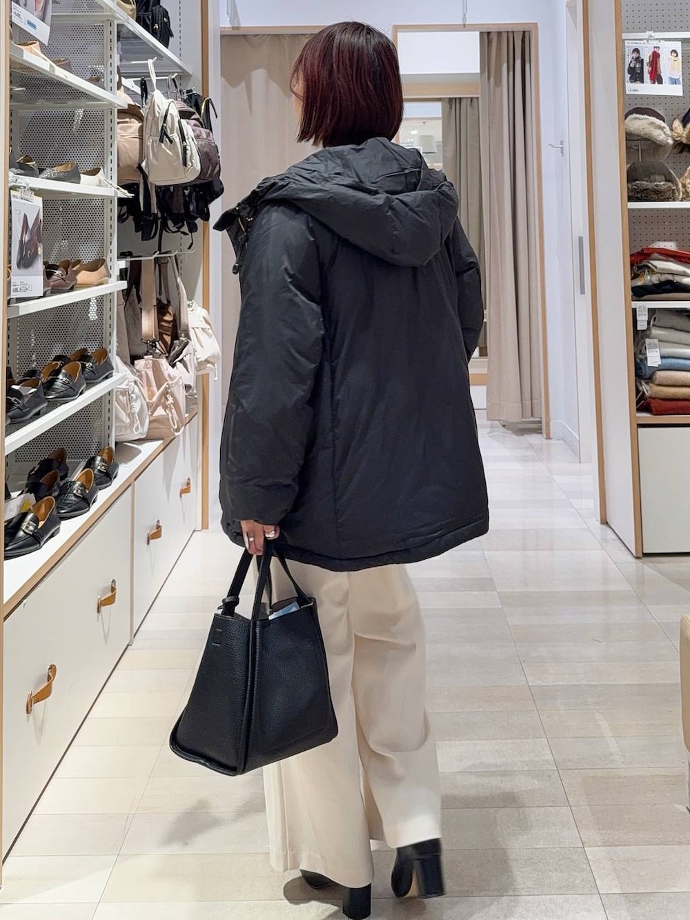 ブラック系のダウンジャケット/コート、ブラック系のトートバッグ、グレー系のその他パンツを着用したレディースの冬コーディネートの4枚目の写真