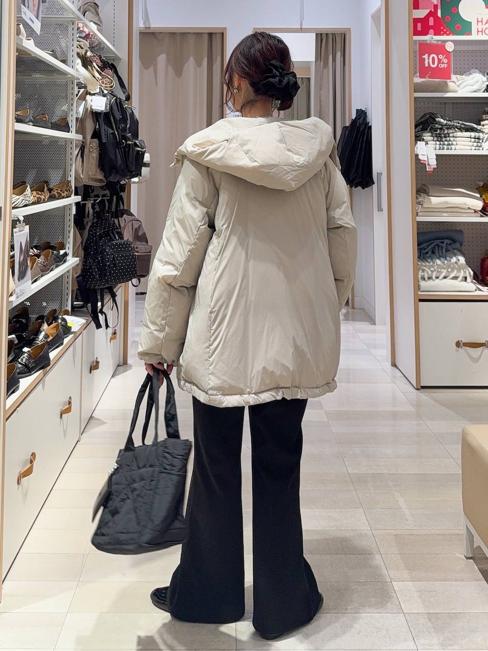 ゴールド系のバレエシューズ、ブラック系のトートバッグ、ベージュ系のダウンジャケット/コートを着用したレディースの冬コーディネートの4枚目の写真