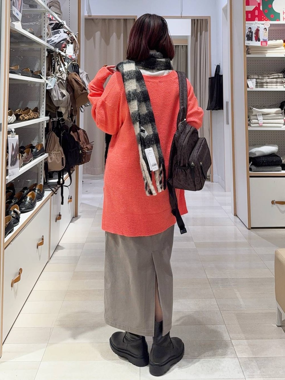 ブラウン系のバックパック/リュック、ブラウン系のスカート、ブラック系のブーツを着用したレディースの冬コーディネートの6枚目の写真