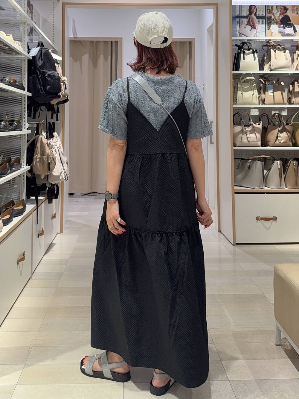 シルバー系のショルダーバッグ、グレー系のサンダル、ブラック系のワンピースを着用したレディースの夏コーディネートの4枚目の写真