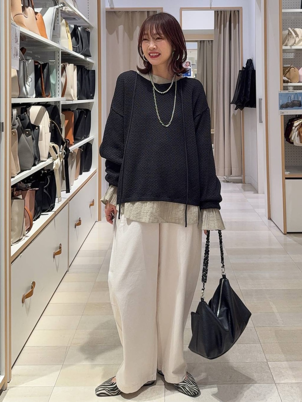 ブラック系のパンプス、ブルー系のデニムパンツ、ホワイト系のスウェットを着用したレディースの春コーディネートの6枚目の写真