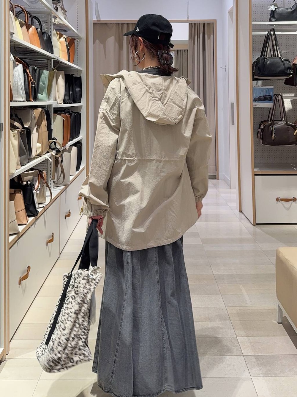 ブラック系のスニーカー、ベージュ系のパーカー、ブラウン系のトートバッグを着用したレディースの春コーディネートの5枚目の写真