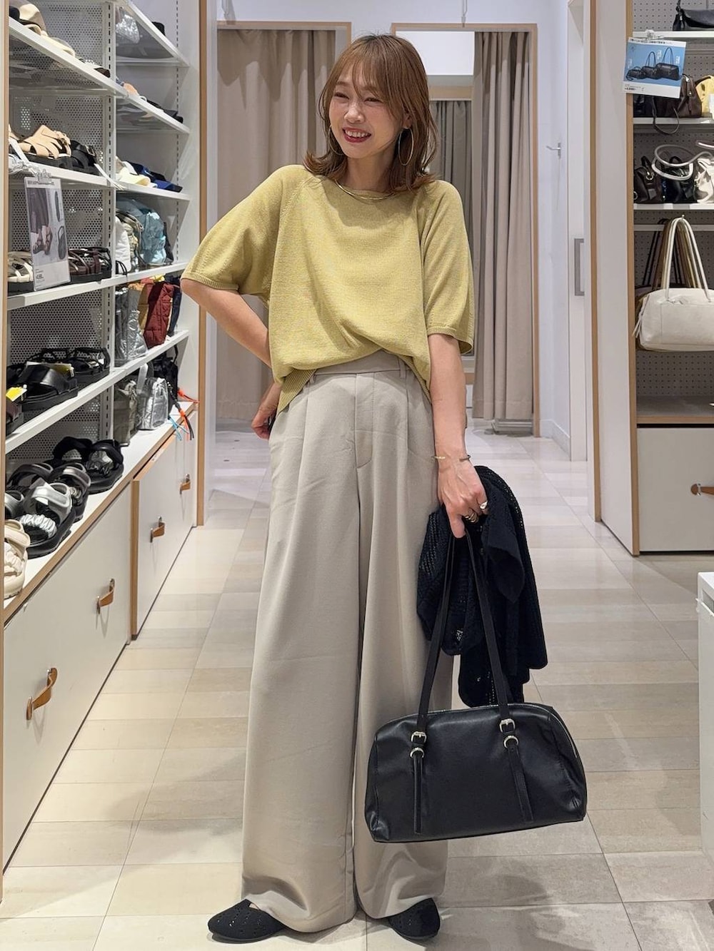 イエロー系のTシャツ/カットソー、ブラック系のトートバッグ、ブルー系のデニムパンツを着用したレディースの夏コーディネートの2枚目の写真