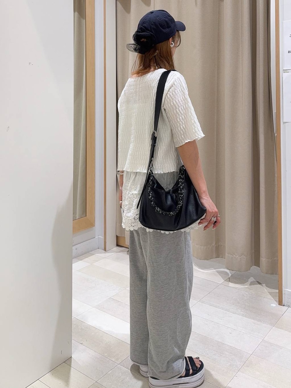 ホワイト系のキャミソール、グレー系のスウェットパンツ、ホワイト系のその他トップスを着用したレディースの春コーディネートの7枚目の写真