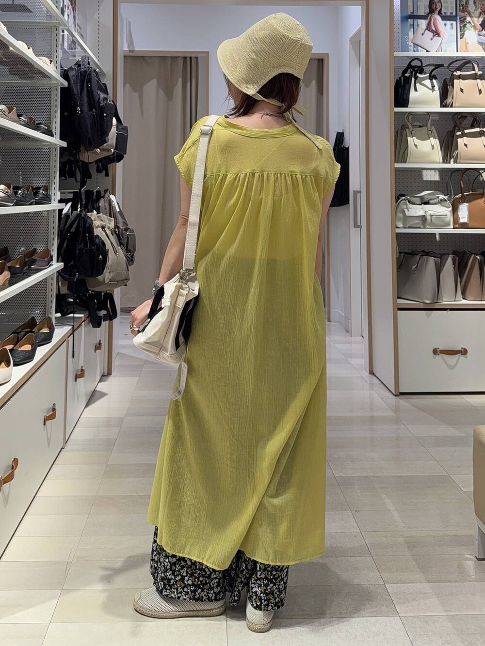 ホワイト系のトートバッグ、ホワイト系のスリッポン、ベージュ系のキャミソールを着用したレディースの夏コーディネートの4枚目の写真