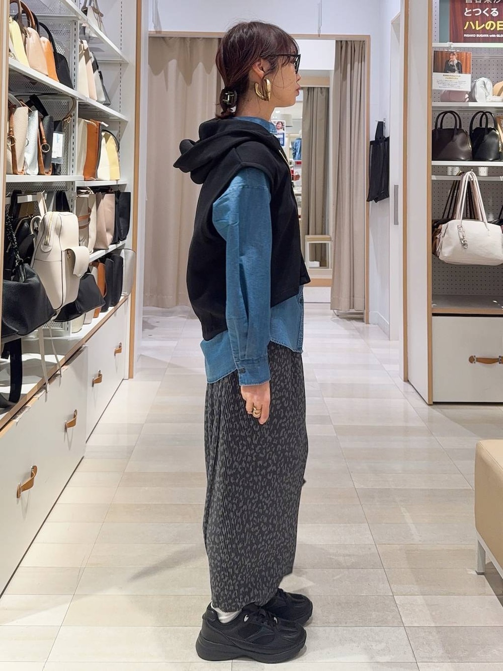 ブラック系のスニーカー、ブルー系のシャツ/ブラウス、ブラック系のベストを着用したレディースの冬コーディネートの4枚目の写真