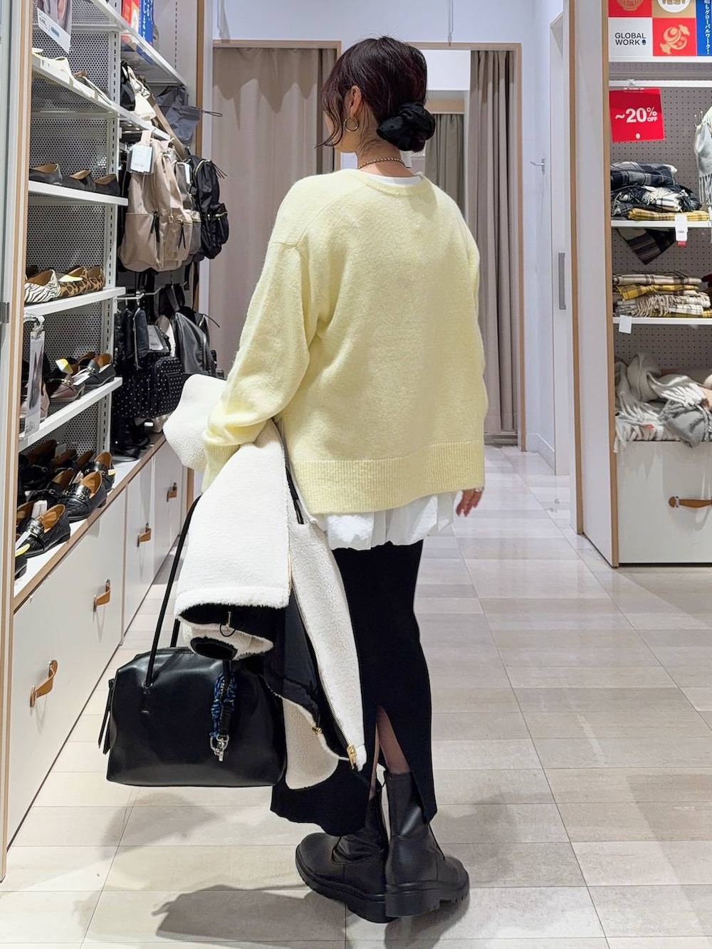 ブラック系のボストンバッグ、ホワイト系のブルゾン、イエロー系のニット/セーターを着用したレディースの冬コーディネートの8枚目の写真