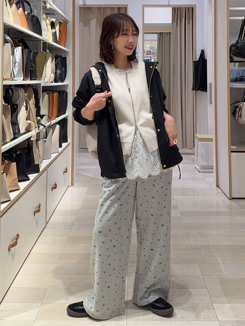 ブラック系のスニーカー、ホワイト系のバックパック/リュック、ブラック系のマウンテンパーカーを着用したレディースの春コーディネートの2枚目の写真