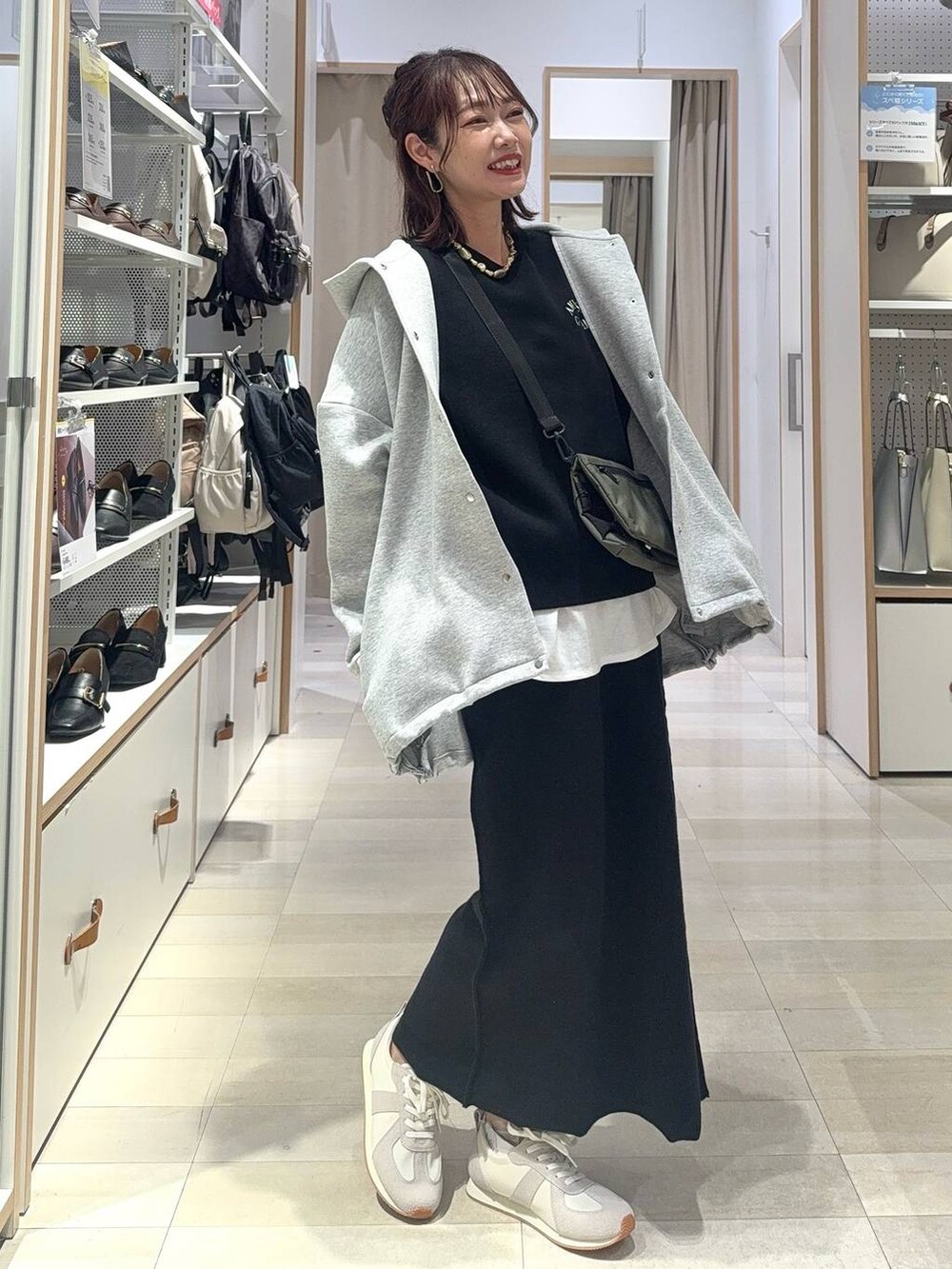 ホワイト系のスニーカー、ブラック系のキャミソール、ブラック系のハンドバッグを着用したレディースの秋コーディネートの3枚目の写真