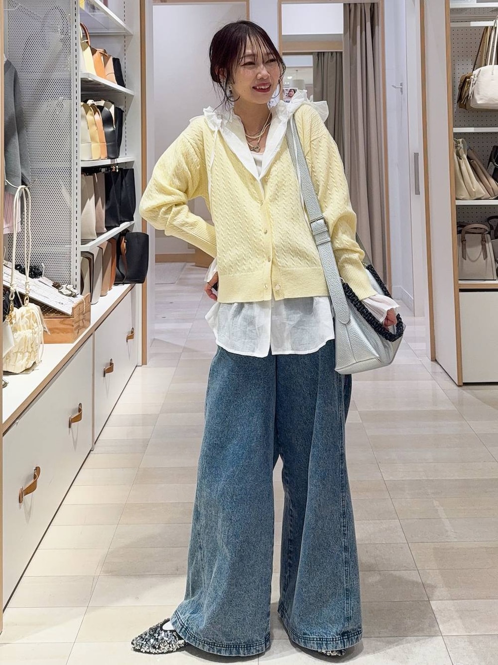 ホワイト系のシャツ/ブラウス、ホワイト系のステンカラーコート、イエロー系のカーディガン/ボレロを着用したレディースの冬コーディネートの3枚目の写真