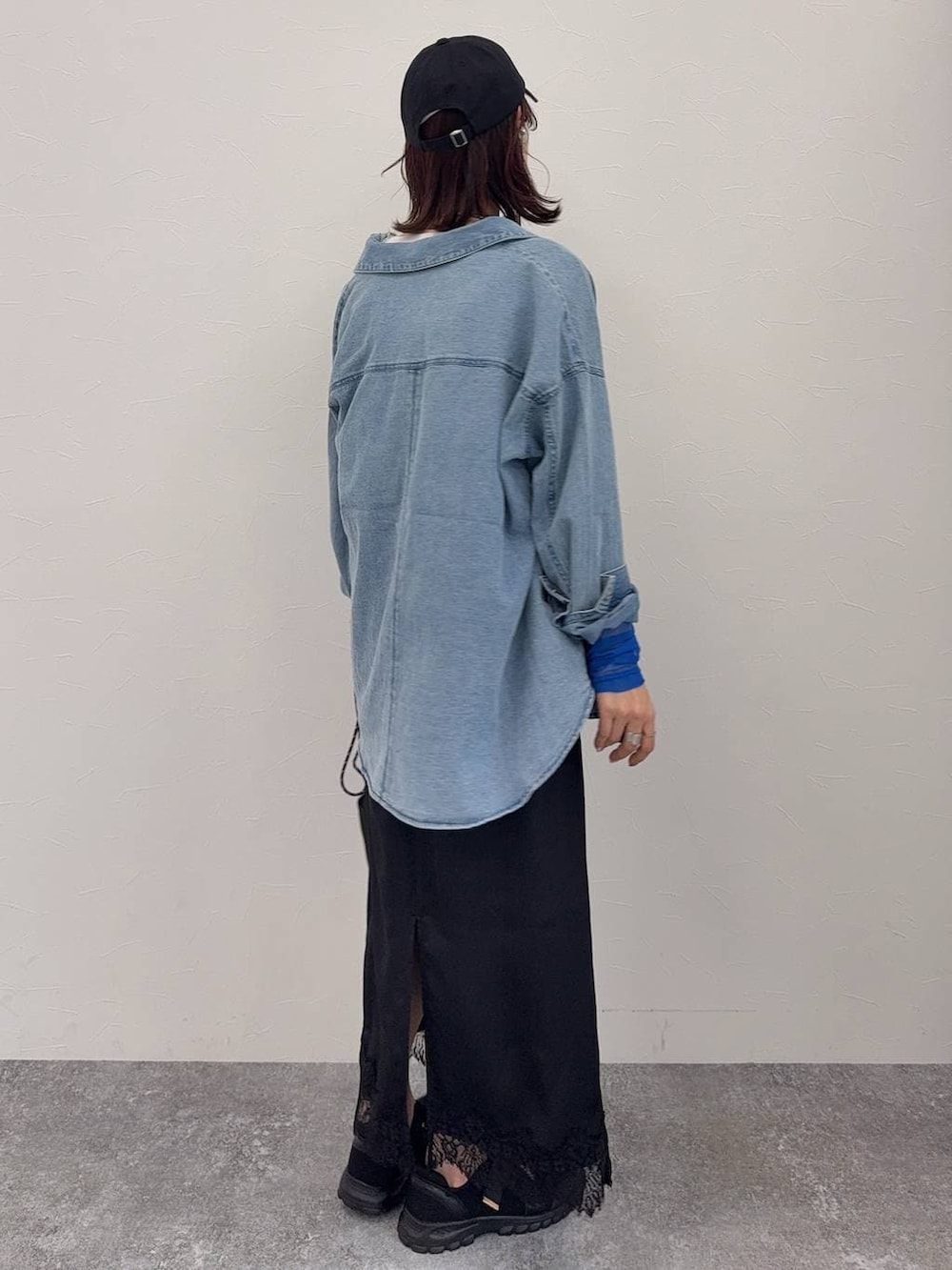 ブラック系のスニーカー、ホワイト系のベスト、シルバー系のネックレスを着用したレディースの春コーディネートの4枚目の写真