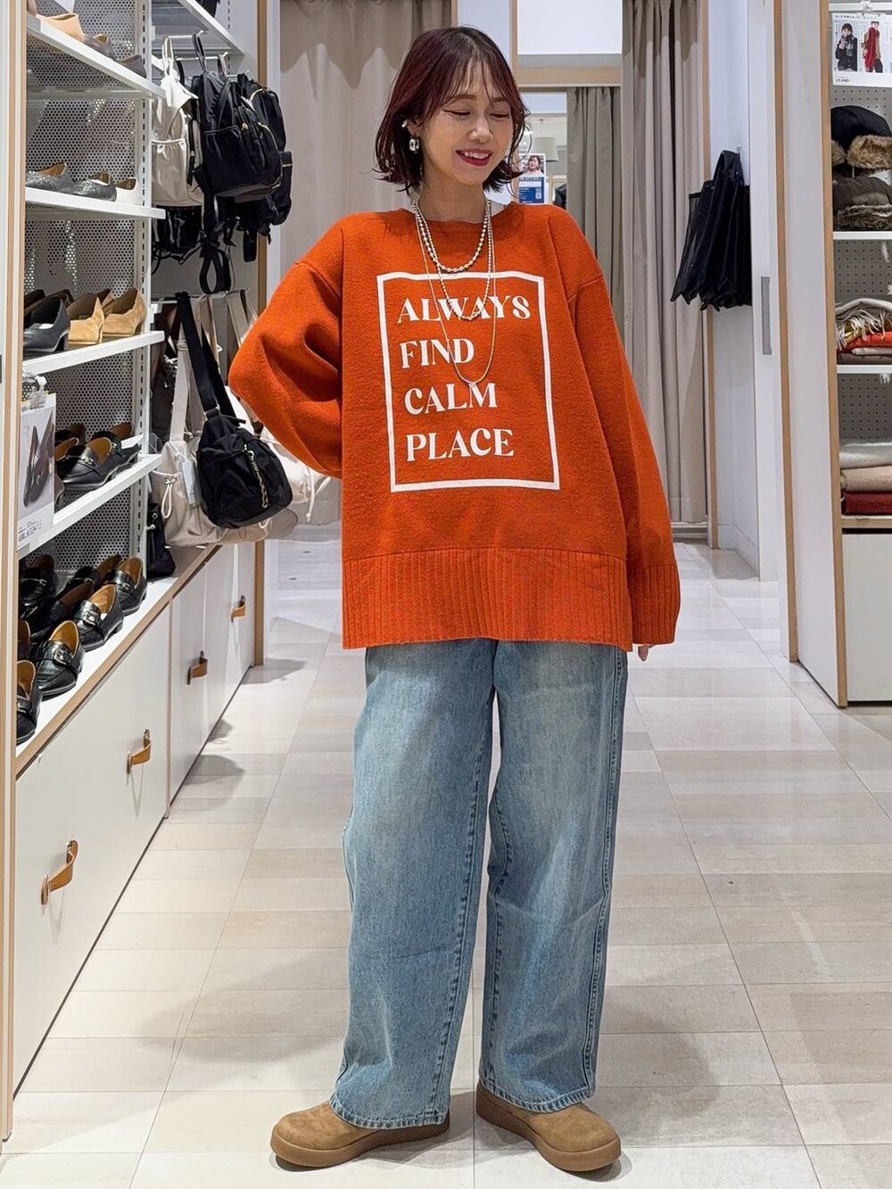 ブラック系のショルダーバッグ、ブルー系のチェスターコート、イエロー系のブーツを着用したレディースの冬コーディネートの8枚目の写真