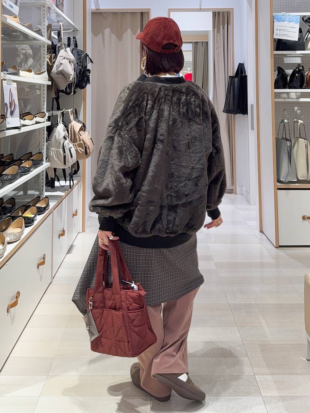 レッド系のトートバッグ、ブラック系のブルゾン、ピンク系のその他パンツを着用したレディースの秋コーディネートの5枚目の写真