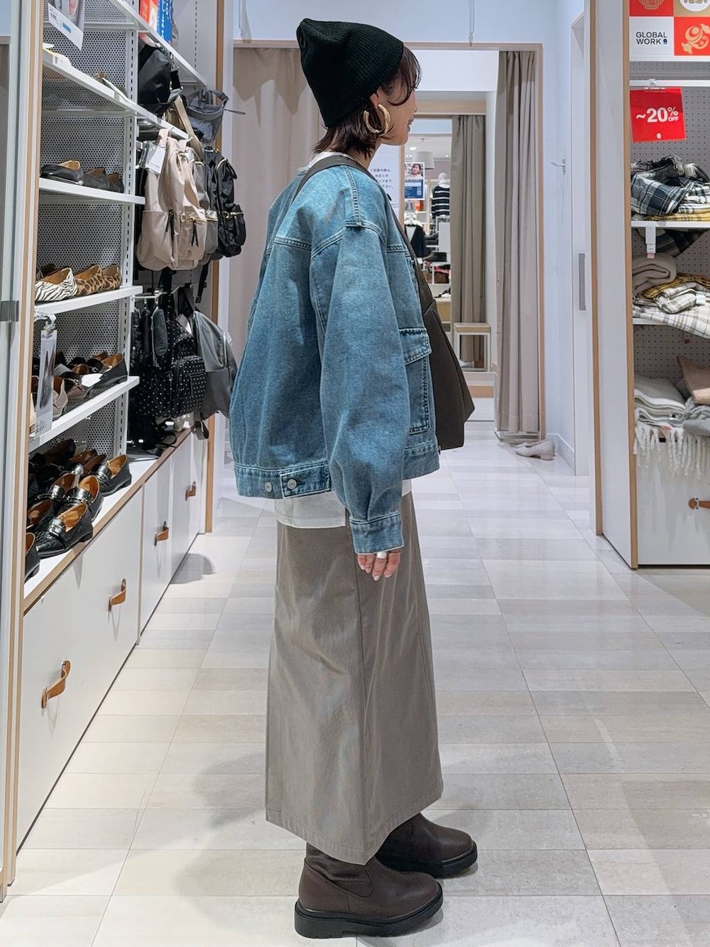 ブラウン系のショルダーバッグ、ブラウン系のスカート、ホワイト系のTシャツ/カットソーを着用したレディースの冬コーディネートの4枚目の写真