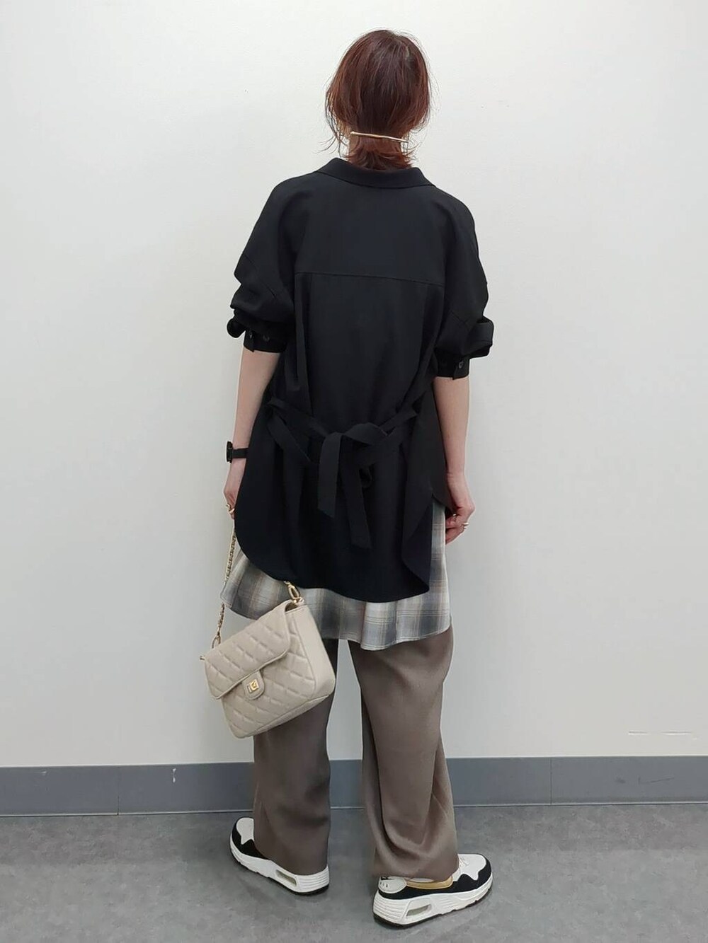 ホワイト系のショルダーバッグ、ブラック系のシャツ/ブラウス、ベージュ系のキャミソールを着用したレディースの春コーディネートの4枚目の写真