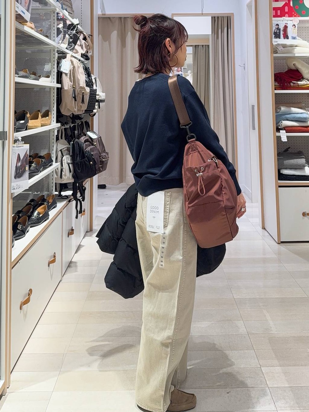 ブラック系のダウンジャケット/コート、ベージュ系のデニムパンツ、ホワイト系のTシャツ/カットソーを着用したレディースの冬コーディネートの6枚目の写真