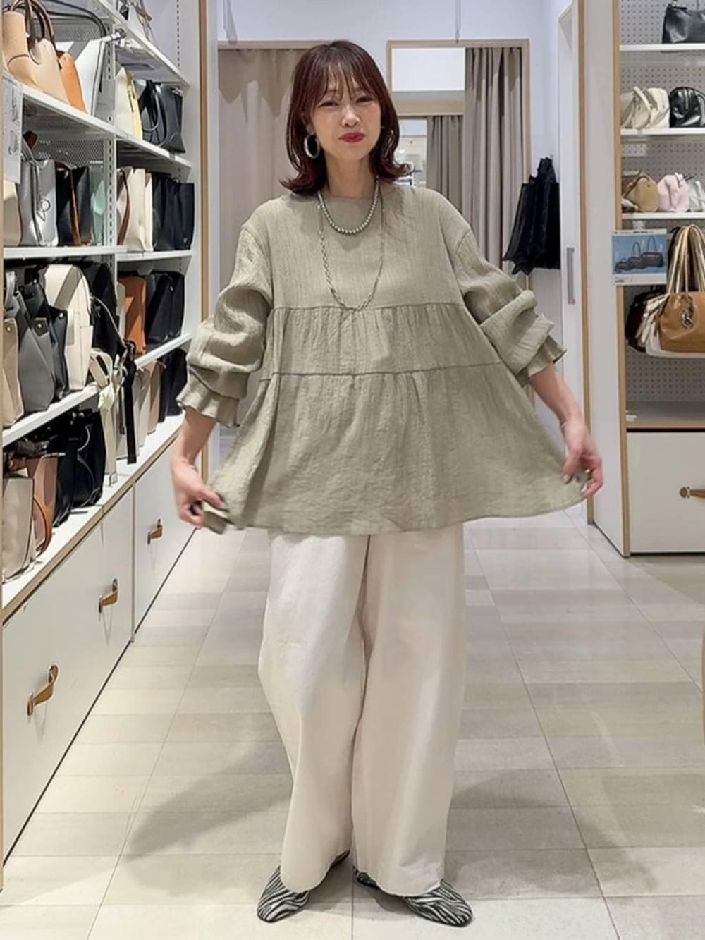 その他のパンプス、ベージュ系のその他パンツ、シルバー系のネックレスを着用したレディースの春コーディネートの2枚目の写真