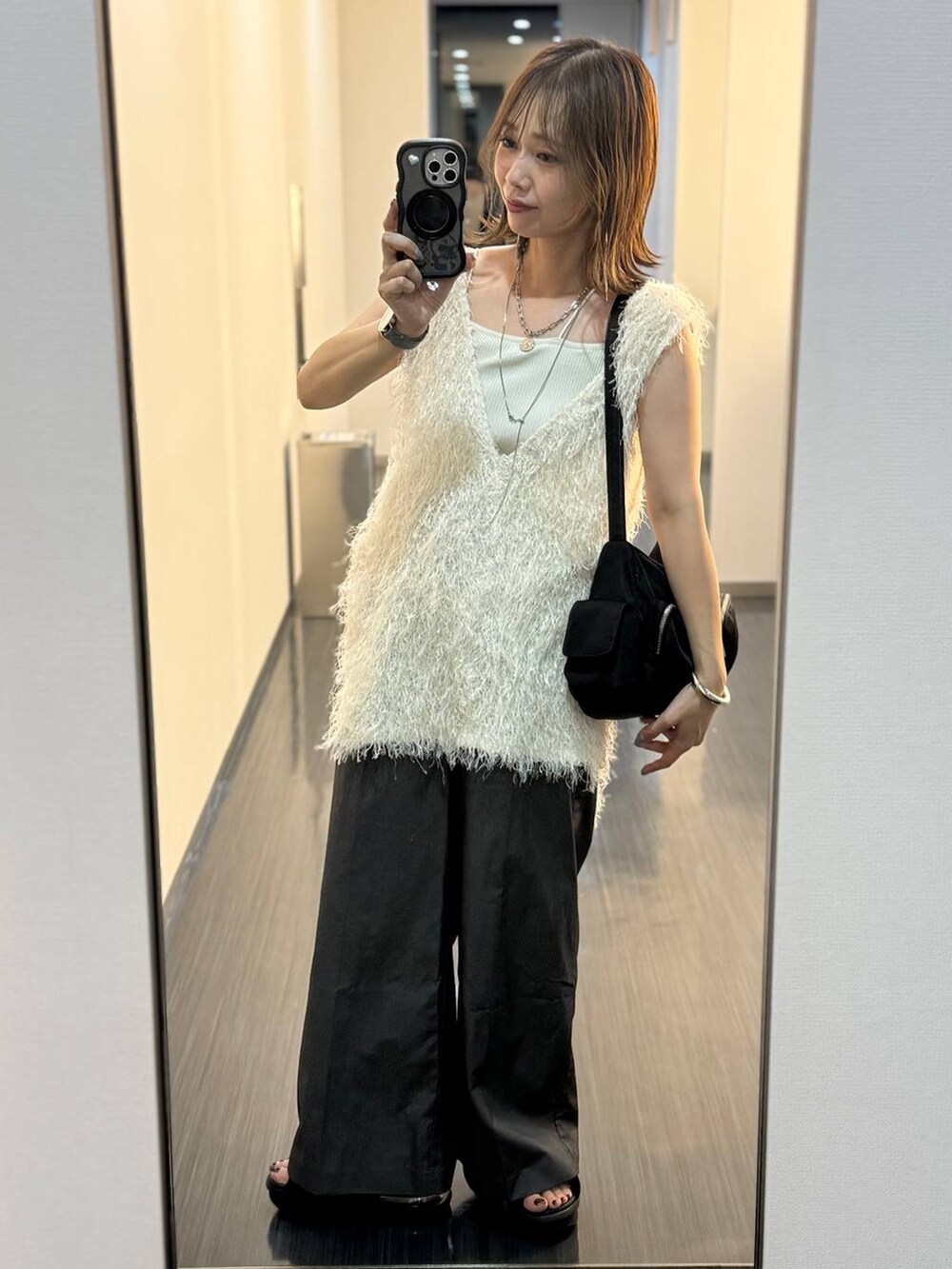 ベージュ系のキャミソール、ホワイト系のチュニック、グレー系のネックレスを着用したレディースの夏コーディネートの2枚目の写真