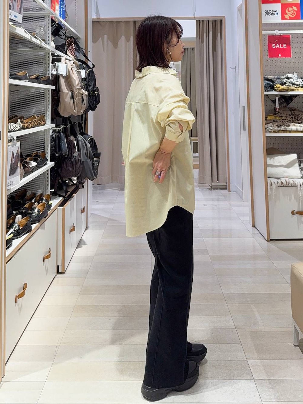 グレー系のニット/セーター、イエロー系のシャツ/ブラウス、ベージュ系のトートバッグを着用したレディースの冬コーディネートの5枚目の写真