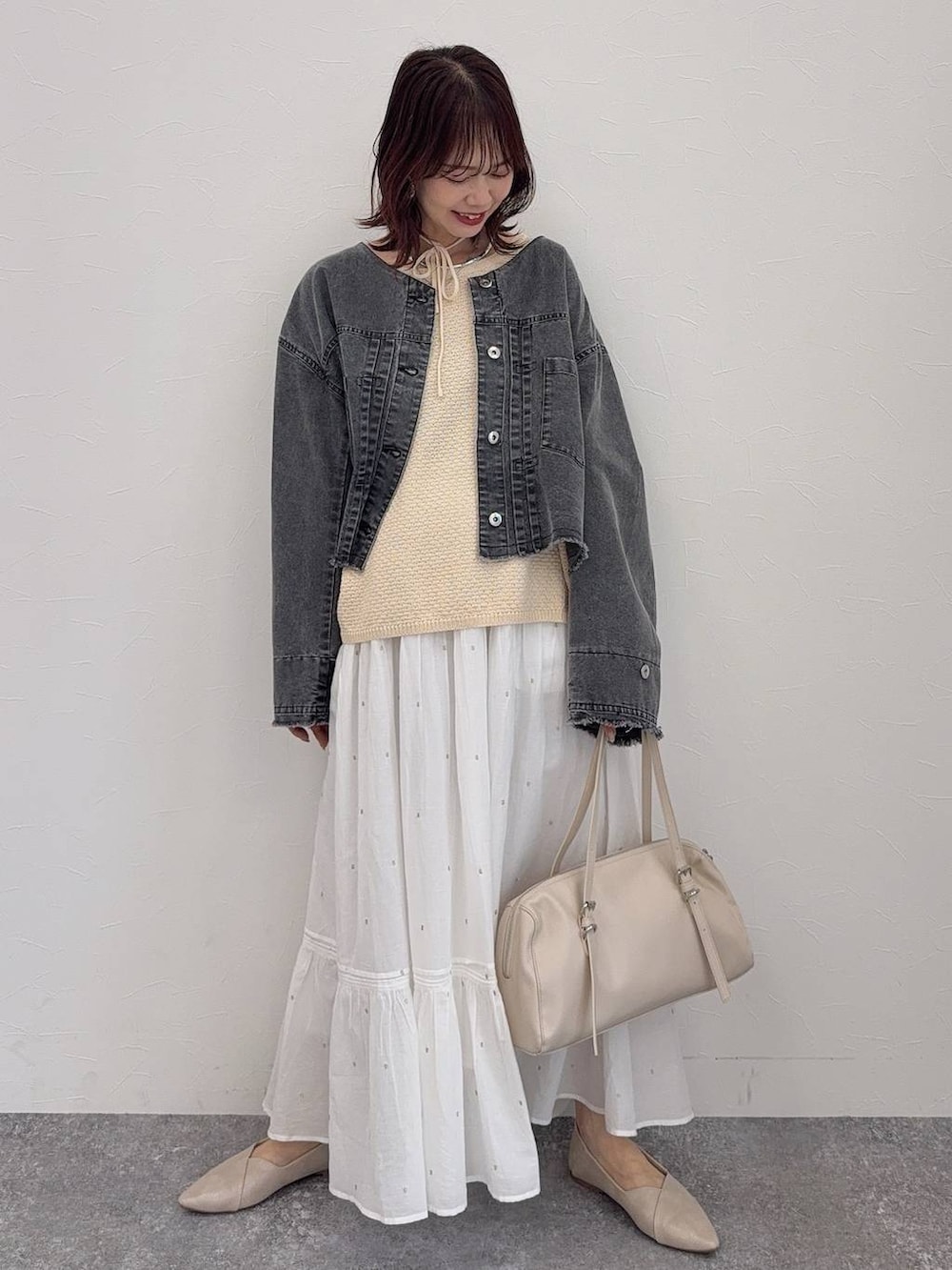 ホワイト系のパンプス、ベージュ系のショルダーバッグ、シルバー系のネックレスを着用したレディースの春コーディネートの2枚目の写真