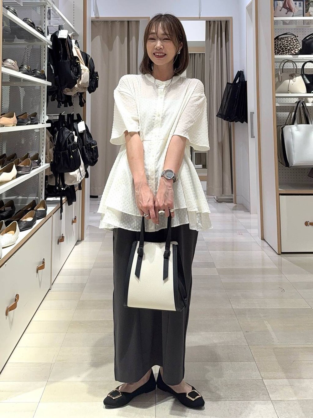 ブラック系のトートバッグ、ブラック系のパンプス、グレー系のその他パンツを着用したレディースの夏コーディネートの2枚目の写真