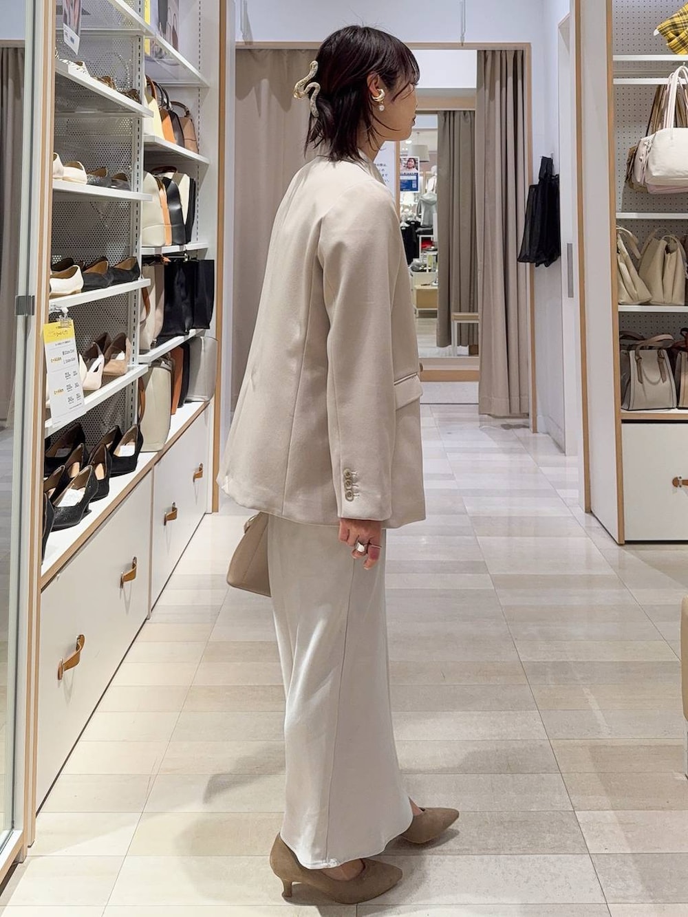 ベージュ系のショルダーバッグ、ベージュ系のパンプス、ホワイト系のキャミソールを着用したレディースの冬コーディネートの5枚目の写真