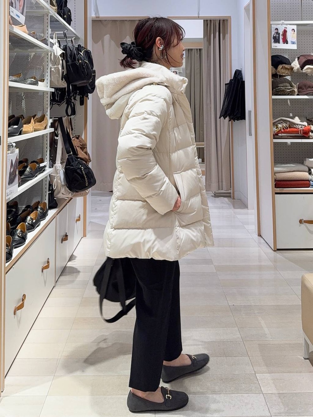 ブラック系のショルダーバッグ、ベージュ系のダウンジャケット/コート、ブラック系のその他パンツを着用したレディースの冬コーディネートの6枚目の写真