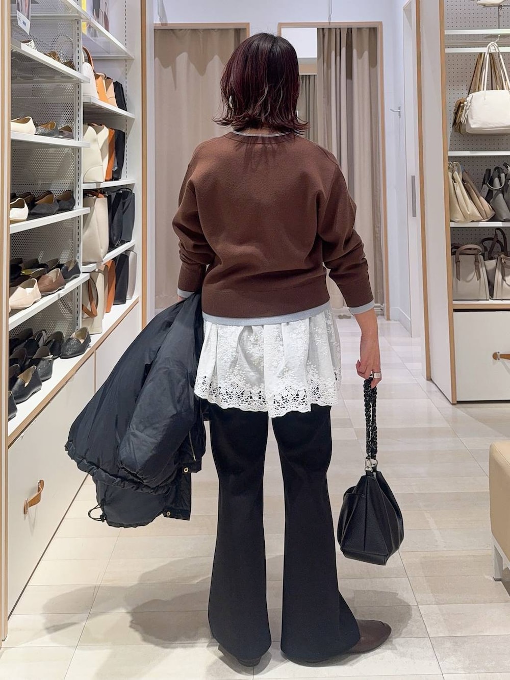 ブルー系のダウンジャケット/コート、ブラウン系のカーディガン/ボレロ、ブラック系のスウェットパンツを着用したレディースの冬コーディネートの6枚目の写真