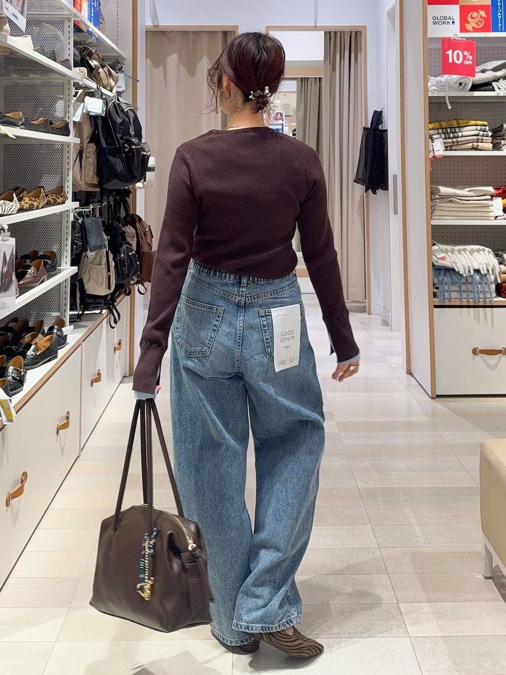 その他のパンプス、ブラウン系のボストンバッグ、ブルー系のデニムパンツを着用したレディースの冬コーディネートの9枚目の写真