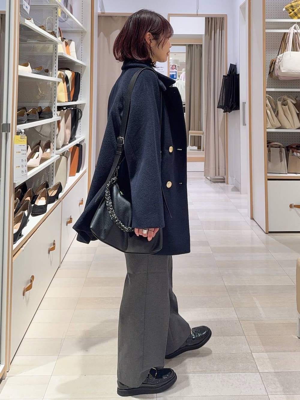 ブラック系のローファー、ブルー系のチェスターコート、グレー系のその他パンツを着用したレディースの冬コーディネートの6枚目の写真
