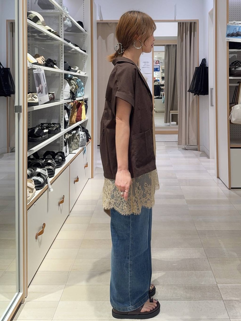 ブルー系のデニムパンツ、ホワイト系のタンクトップ、ブラウン系のシャツ/ブラウスを着用したレディースの春コーディネートの5枚目の写真