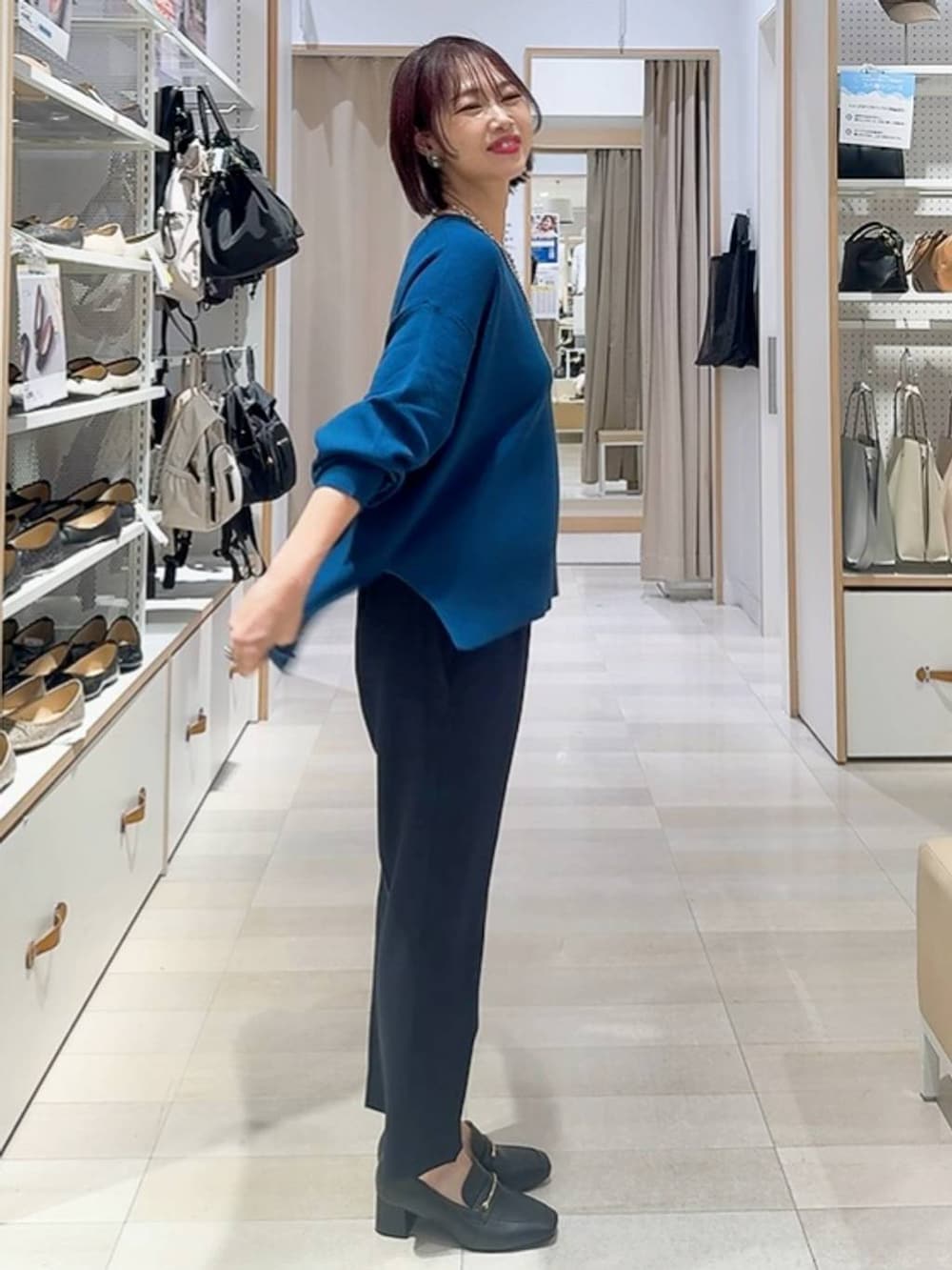 ブラック系のローファー、ホワイト系のショルダーバッグ、ベージュ系のダウンジャケット/コートを着用したレディースの秋コーディネートの6枚目の写真