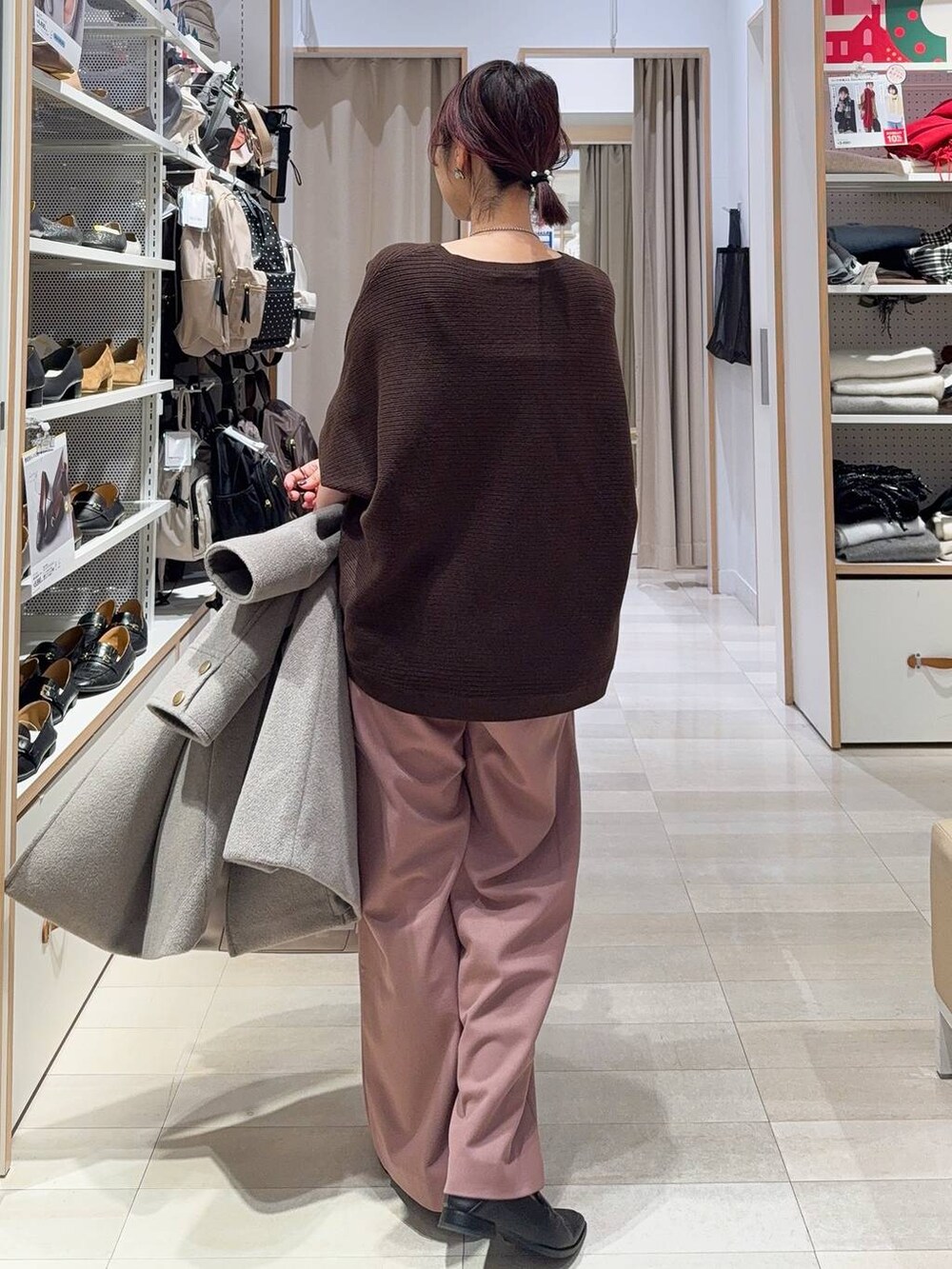 ブラック系のボストンバッグ、ベージュ系のチェスターコート、ピンク系のその他パンツを着用したレディースの冬コーディネートの8枚目の写真